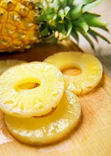 Pineapple slices being pre-treated to retain their golden color before drying