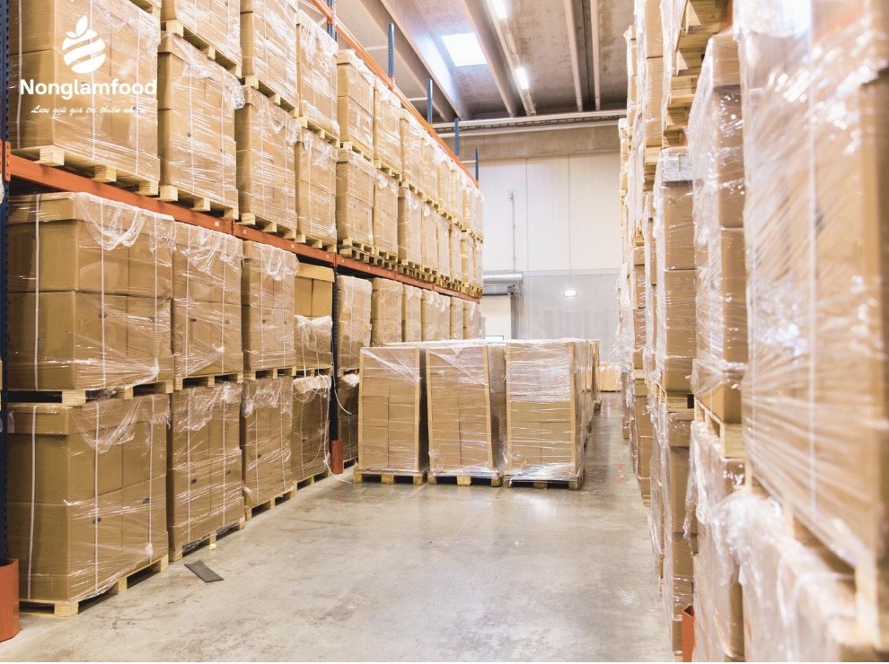 Pallets of packaged fruit products stored in Nong Lam Food's modern warehouse facility