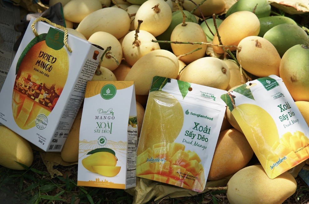 Nong Lam Food premium dried mango products packaged and displayed alongside fresh yellow mangoes