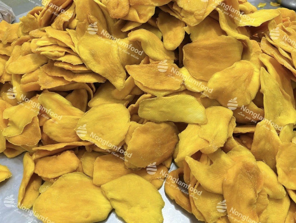 A large pile of vibrant, premium soft dried mango slices rich in beta-carotene